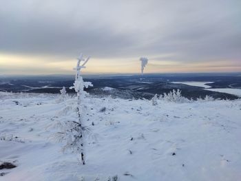 Scenic view of snow covered land against sky