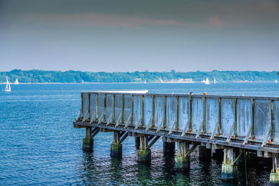 Pier over sea against blue sky