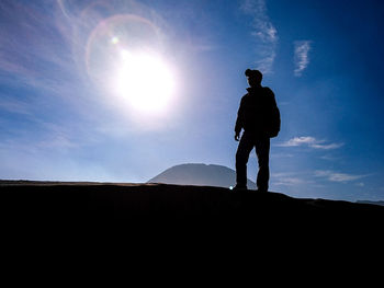 Silhouette man standing on mountain against sky