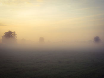 Scenic view of field against sky at sunset