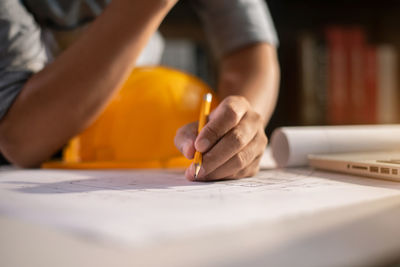 Midsection of man working on table