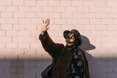 Full length of woman standing against wall