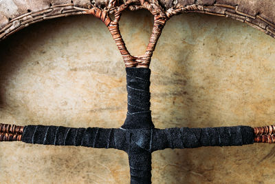 Close-up of tambourine with leather braided handle