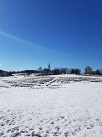 Scenic view of snow covered landscape against clear blue sky