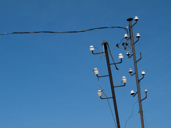 Low angle view of cables against clear blue sky