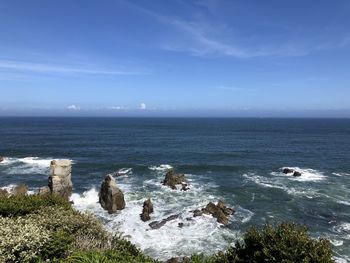 Scenic view of sea against sky. hard wave into stone at coast.