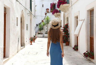 Woman walking on street amidst buildings