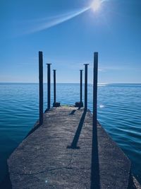 Pier over sea against blue sky