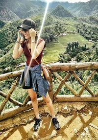 Full length of woman standing on mountain against plants