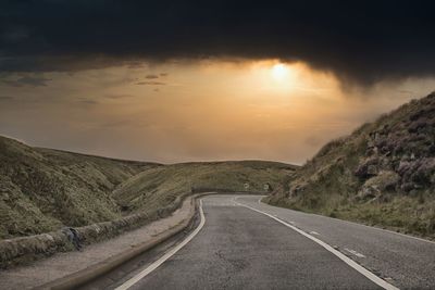 Empty road against sky during sunset