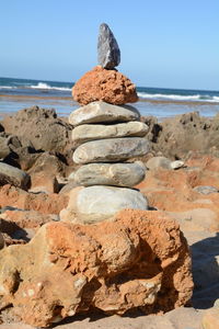 Stack of rocks on beach against sky