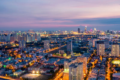 Illuminated cityscape against sky at night