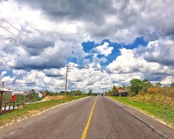 Road by trees against sky