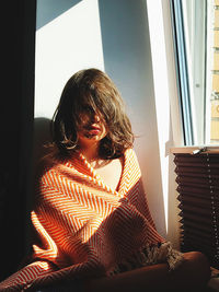Girl sitting by window at home