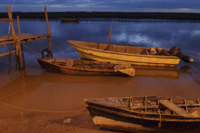 Boats moored on shore against sky