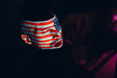 Close-up of woman against black background