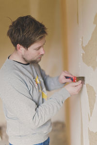 Man removing old wallpaper