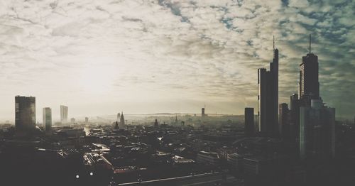 View of cityscape against cloudy sky