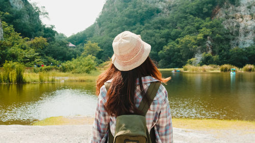 Woman looking at lake against trees