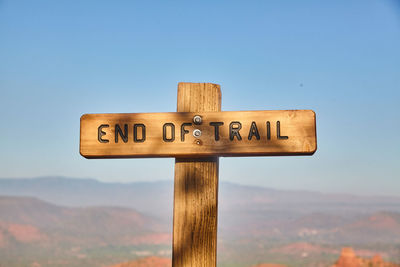 Low angle view of information sign against blue sky