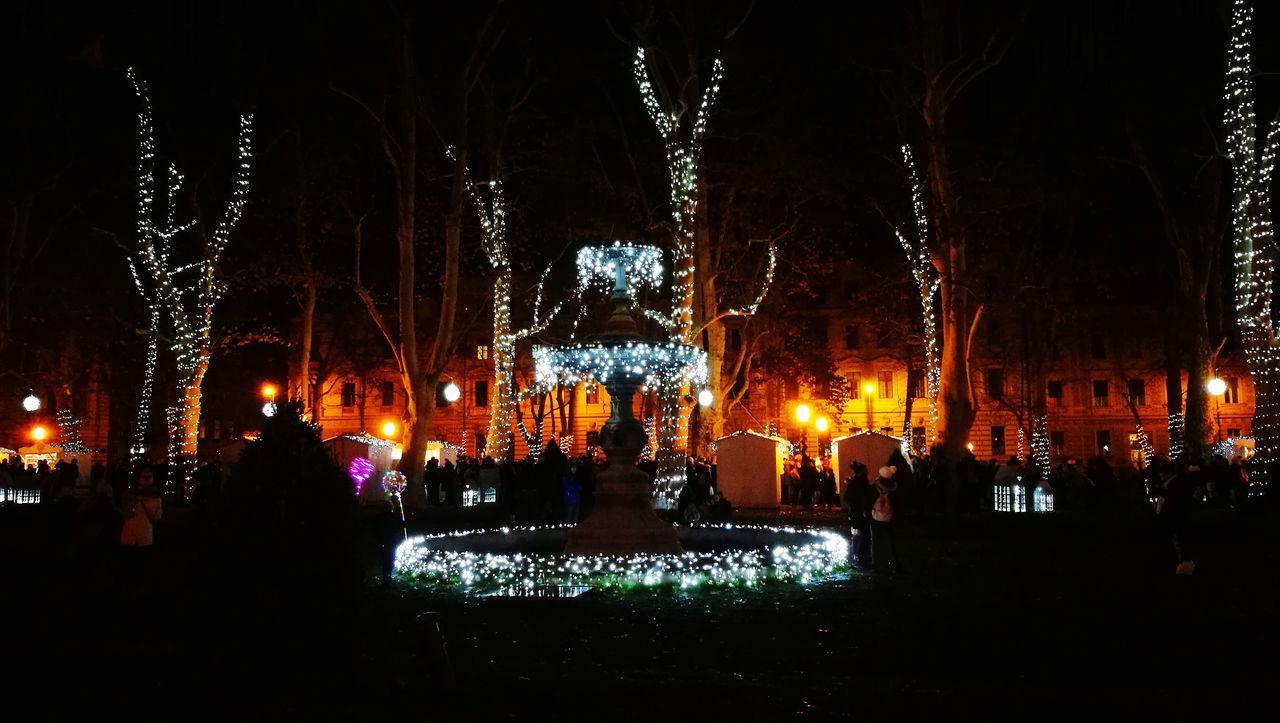 PEOPLE ON ILLUMINATED STREET DURING NIGHT