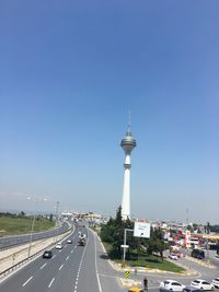 Vehicles on road against clear sky