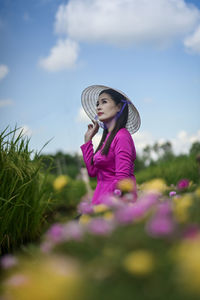 Full length of woman standing on field against sky