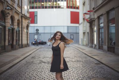 Full length of woman with arms raised in city