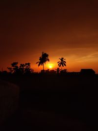 Silhouette palm trees against sky during sunset