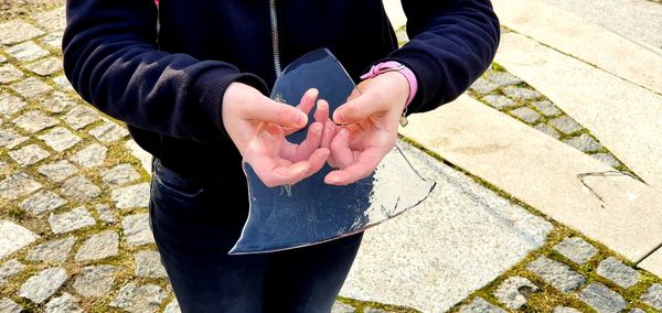 High angle view of woman holding hands on footpath