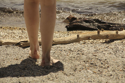 Low section of man standing on beach