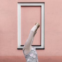 Close-up of person standing against white wall