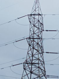 Low angle view of electricity pylon against sky