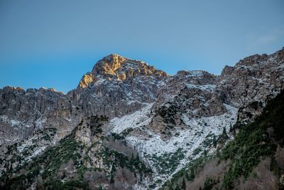 Low angle view of rock formation against clear blue sky