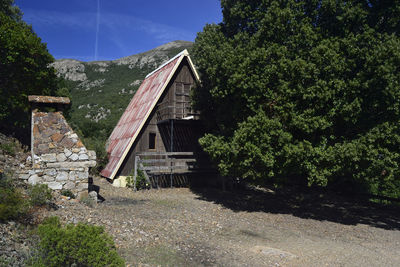 Abandoned building and trees against sky