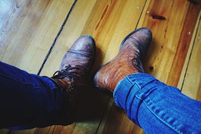 Low section of man standing on hardwood floor