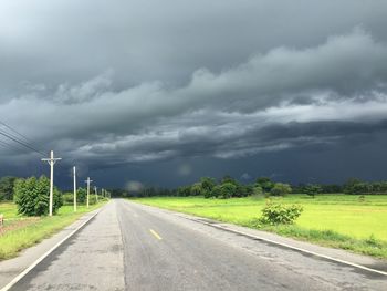 Road by field against sky