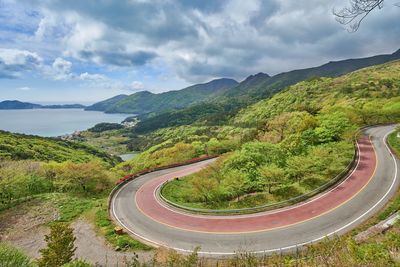 Scenic view of road by mountains against sky