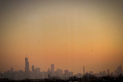 Buildings in city during sunset