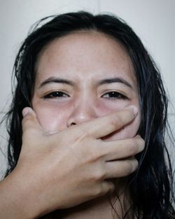 Cropped hand of man covering woman mouth