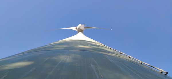 Wind turbine photographed from below vertically upwards along the mast against the sky