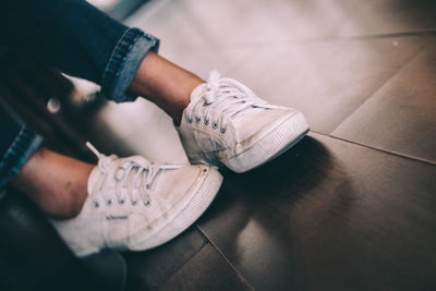 Low section of man wearing shoes on hardwood floor