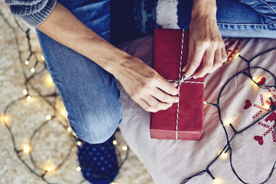 High angle view of woman wrapping christmas gift