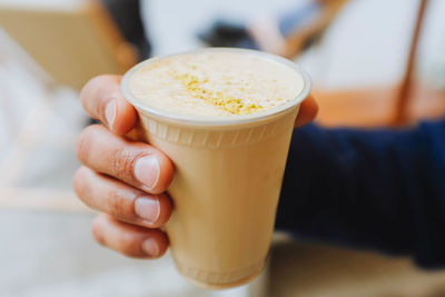 Close-up of hand holding coffee cup