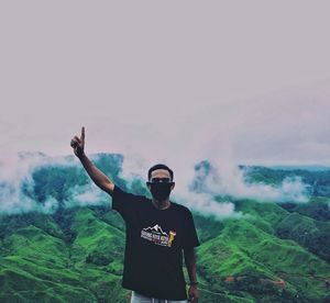 Young man standing on land against sky