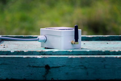 Close-up of old container on table against wall