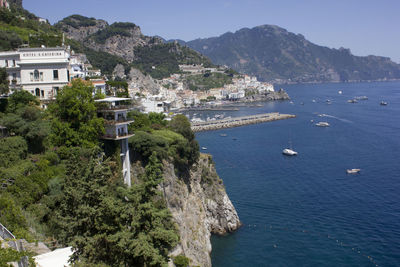 High angle view of sea and buildings against mountain