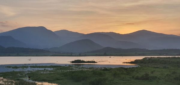 Scenic view of lake against sky during sunset