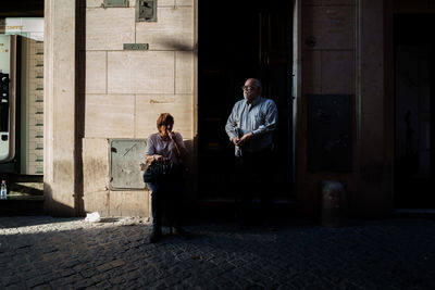 Full length of man sitting on mobile phone