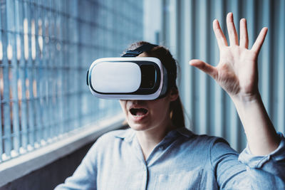 Woman with vr goggles and facial expression enjoying virtual reality experience